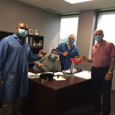men in an office wearing masks and having a meeting