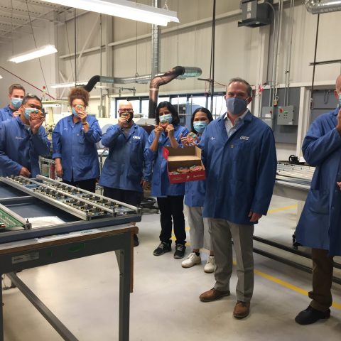Group of production workers in blue coats and masks
