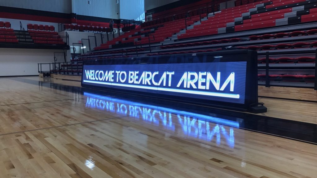 indoor scoring table in front of bleachers