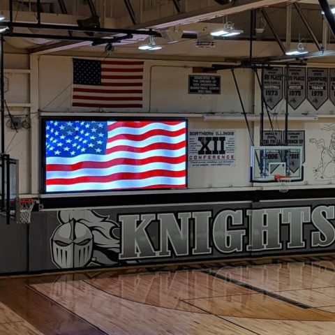 video scoreboard ishowing the american flag in the gym at Kaneland high school