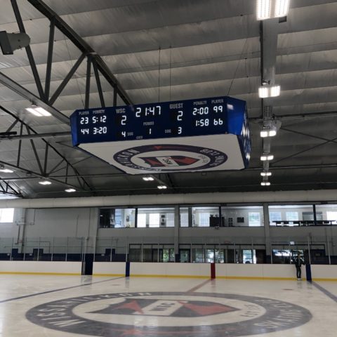 small four sided hockey scoreboard at centre ice of an arena