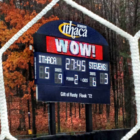 looking at a soccer scoreboard through the goal nets