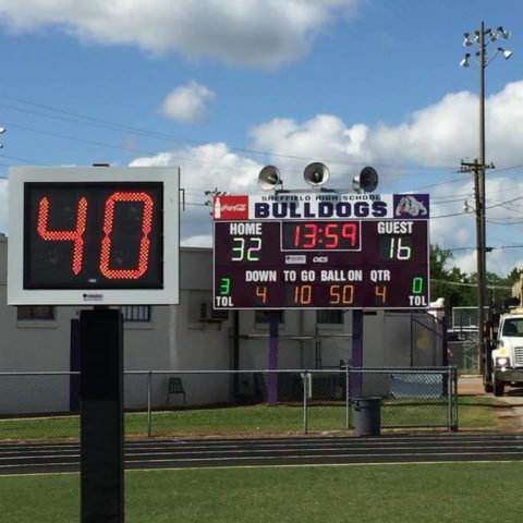 play clock on a football field with a scoreboard in the background