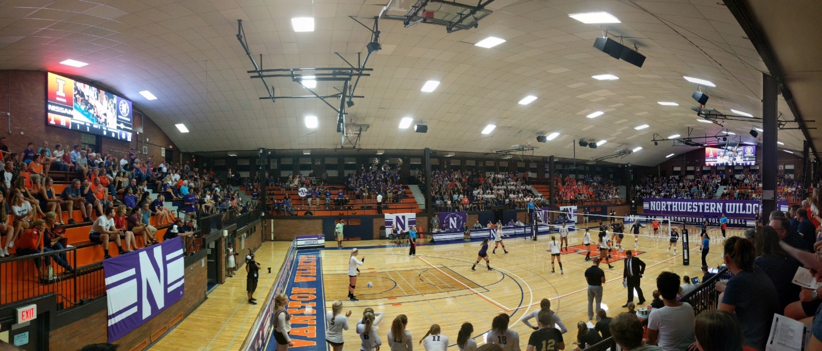 Panaramic view of a high school gym where a basketball game is being played