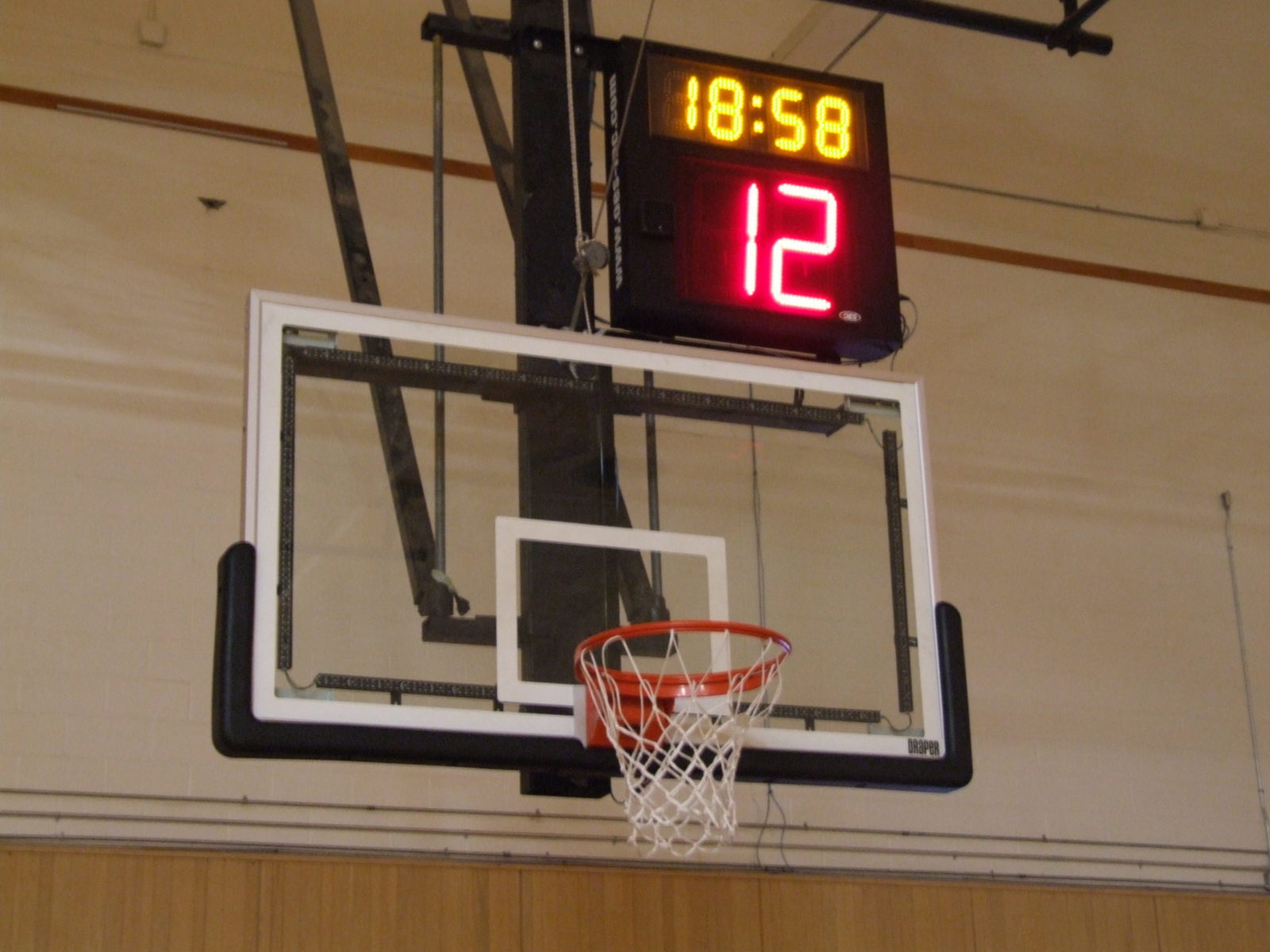 A shot clock above an indoor basketball net.