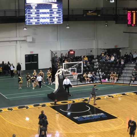 view from the bleachers of a basketball net and video display