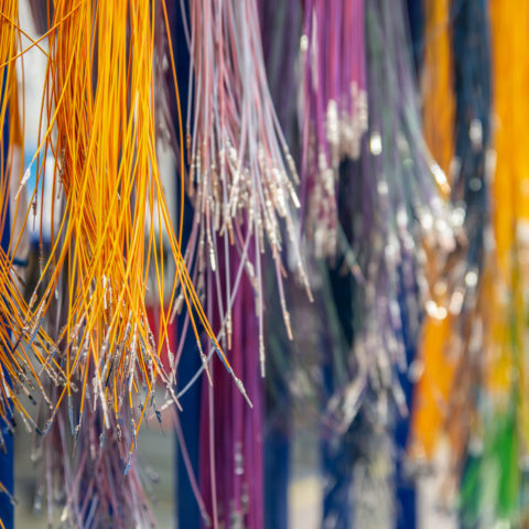 The ends of brightly coloured wires grouped by colour.