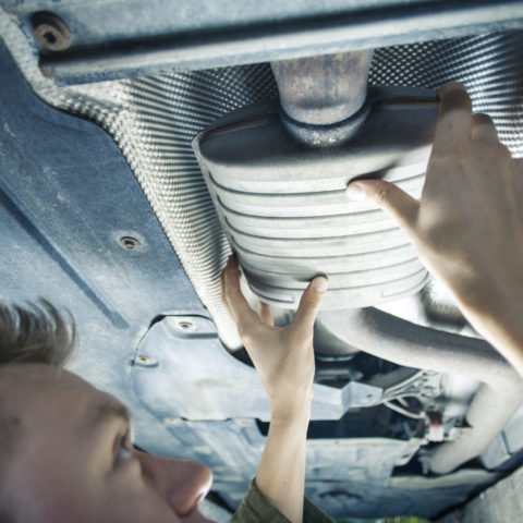 Mechanic fixing part at on the bottom of a car.