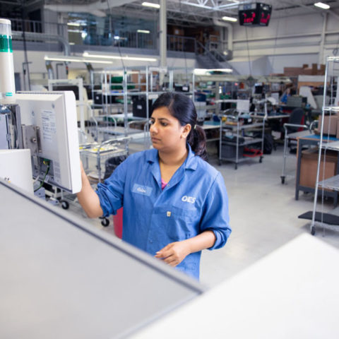 Woman working on factory machine