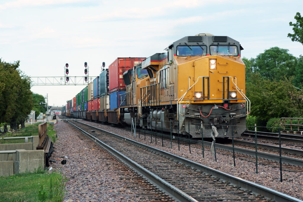 Yellow train with lots of cargo heading towards the camera.